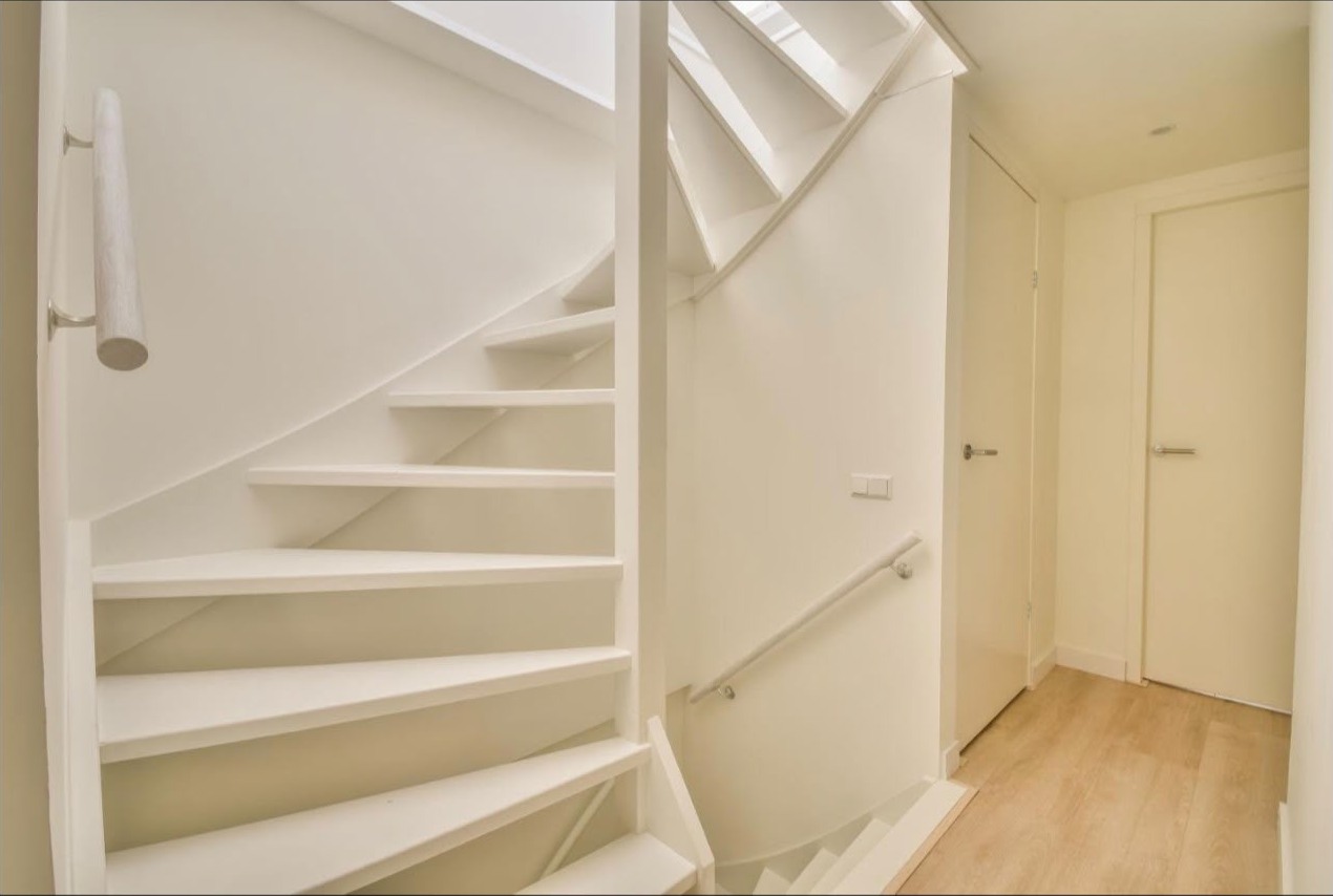 Bright white painted staircase, handrail and door frames in a hallway